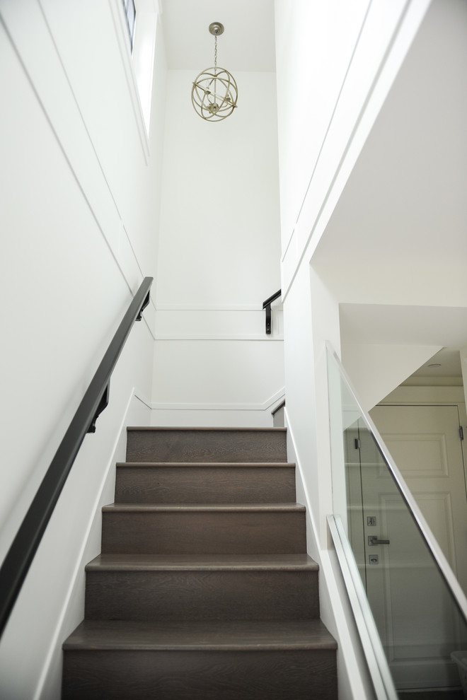 This is an example of a medium sized modern wood l-shaped staircase in Vancouver with wood risers.