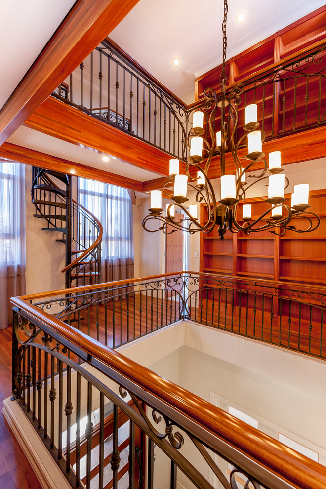 Пример оригинального дизайна: большая винтовая лестница в классическом стиле с деревянными ступенями