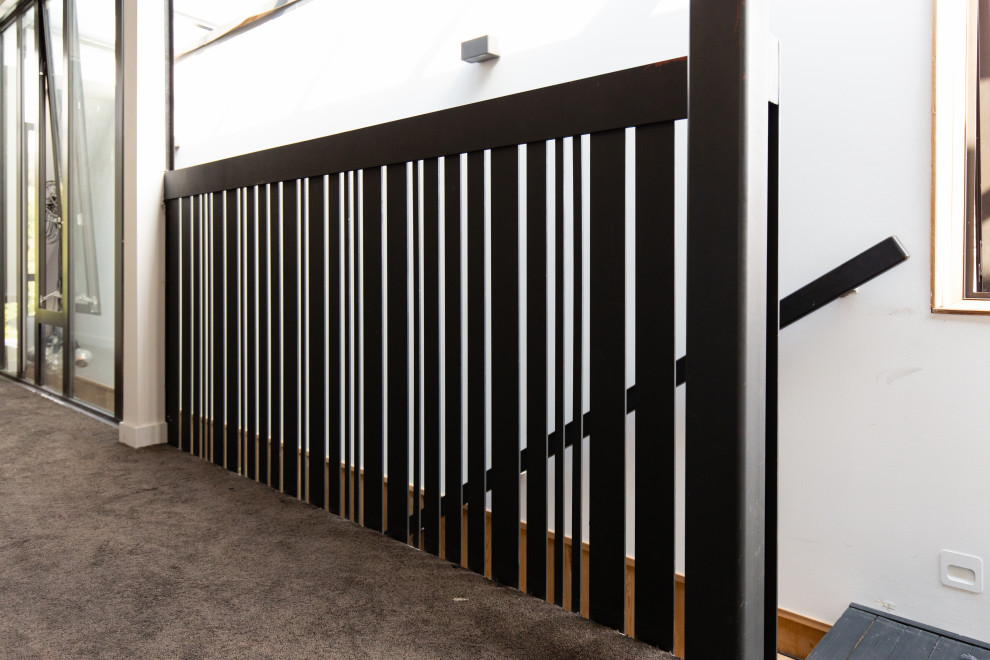 Medium sized modern wood straight metal railing staircase in Auckland with open risers.