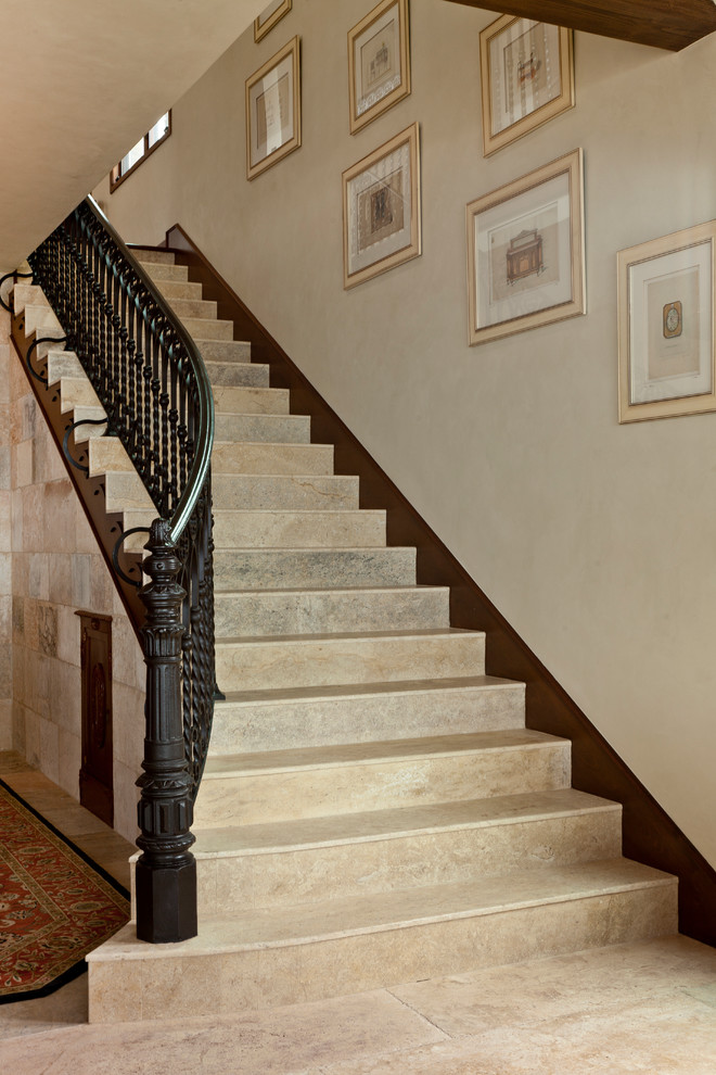 Пример оригинального дизайна: лестница в средиземноморском стиле с ступенями из известняка, подступенками из известняка и кладовкой или шкафом под ней