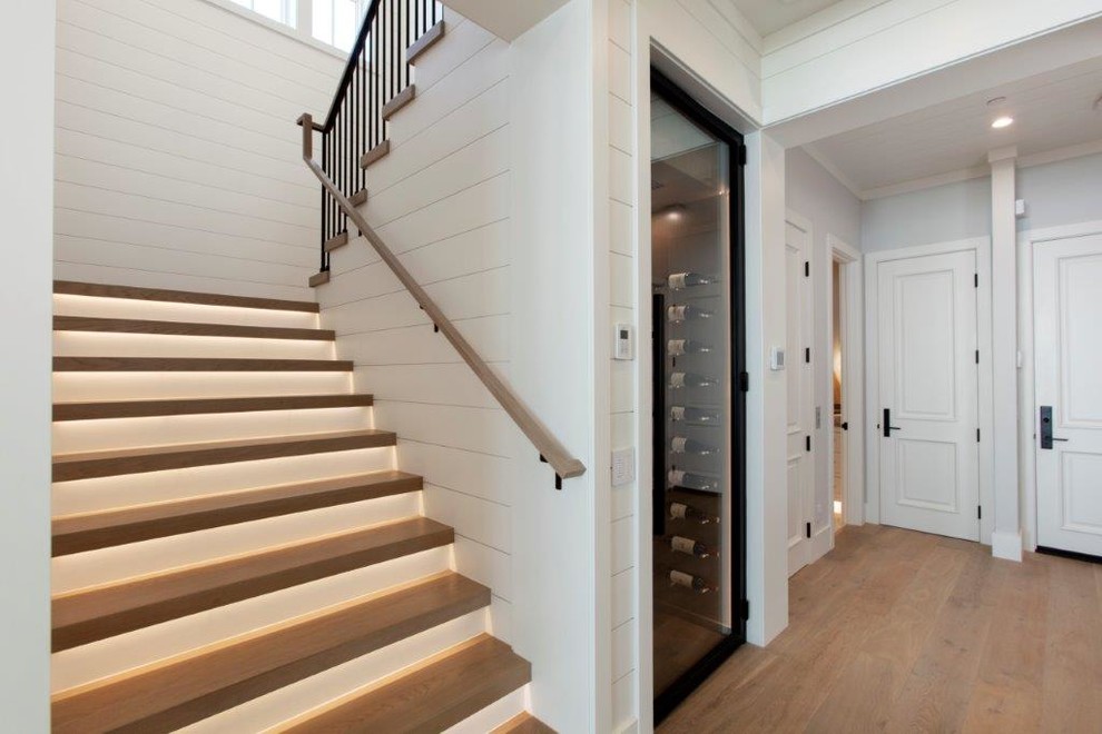 На фото: п-образная лестница среднего размера в морском стиле с деревянными ступенями, крашенными деревянными подступенками и перилами из смешанных материалов с