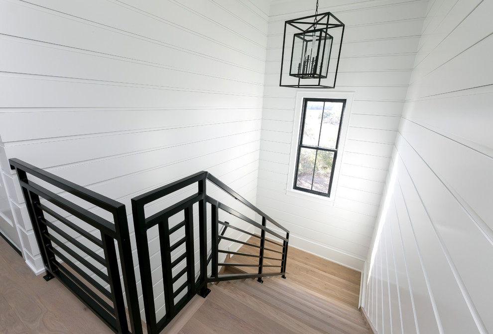 Diseño de escalera en U con escalones de madera y barandilla de metal
