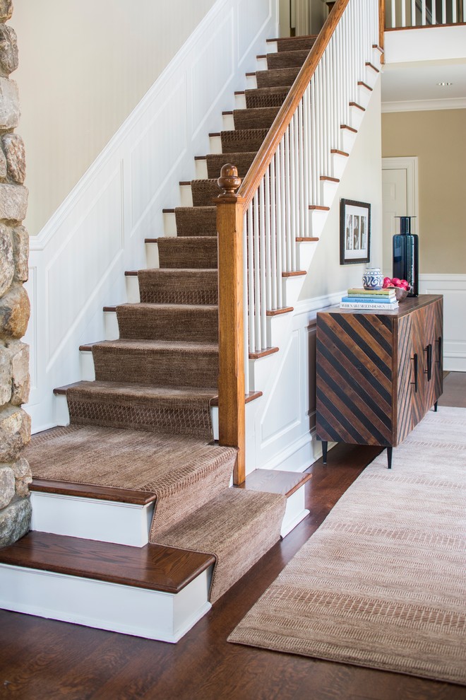 На фото: большая прямая лестница в стиле фьюжн с ступенями с ковровым покрытием, ковровыми подступенками и деревянными перилами с