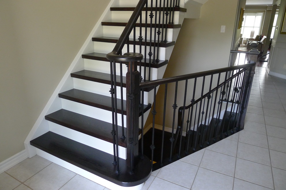 Cette photo montre un escalier peint tendance en L de taille moyenne avec des marches en bois et un garde-corps en bois.