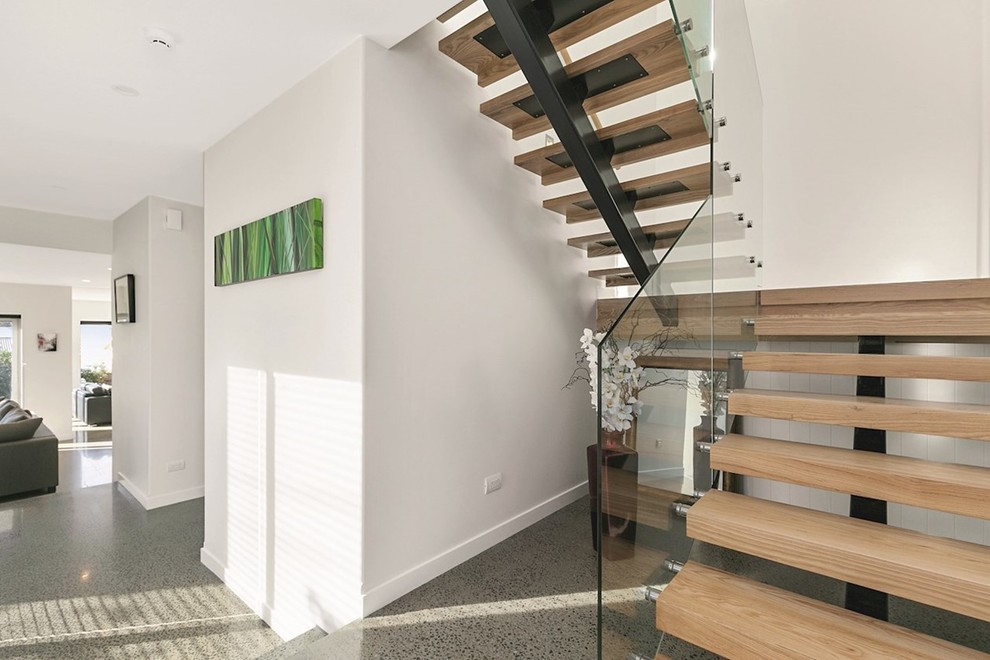Design ideas for a large contemporary wood u-shaped staircase in Wellington with glass risers.