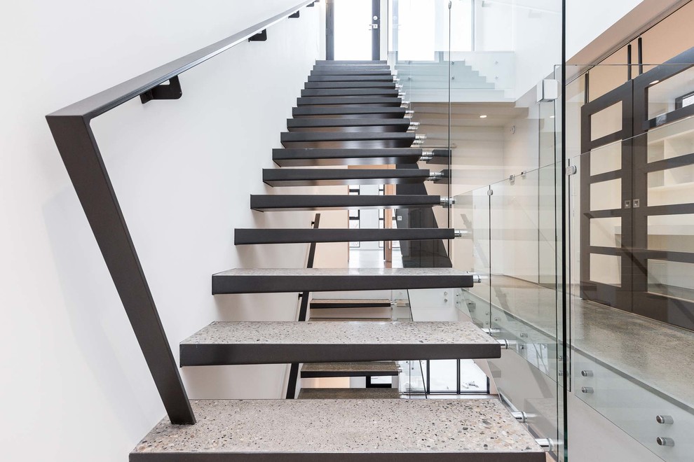 Réalisation d'un escalier sans contremarche droit minimaliste en béton de taille moyenne avec un garde-corps en métal.
