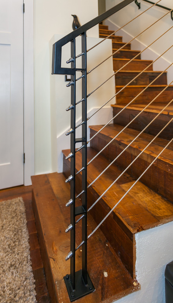 Exemple d'un escalier chic en L de taille moyenne avec des marches en bois, des contremarches en bois et un garde-corps en métal.