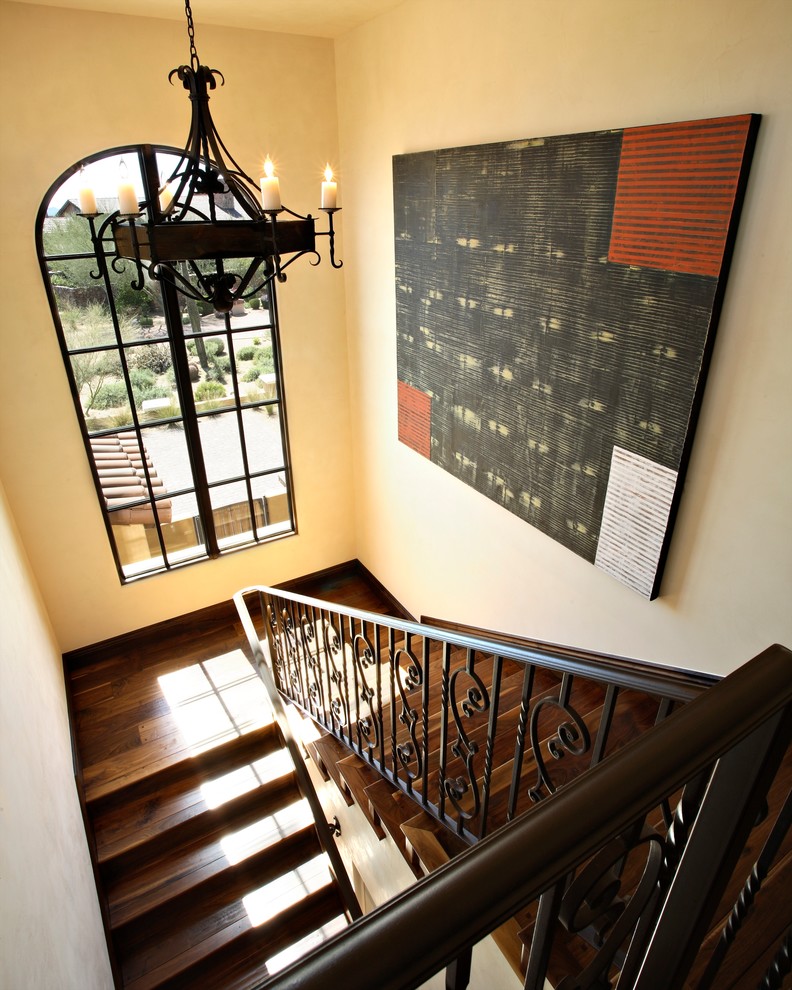 Imagen de escalera en U mediterránea grande con contrahuellas de madera, barandilla de metal y escalones de madera
