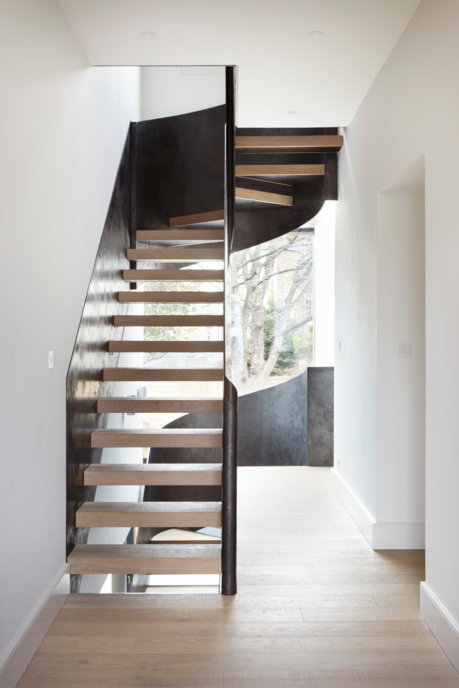 Источник вдохновения для домашнего уюта: большая изогнутая лестница в современном стиле с деревянными ступенями и металлическими перилами без подступенок