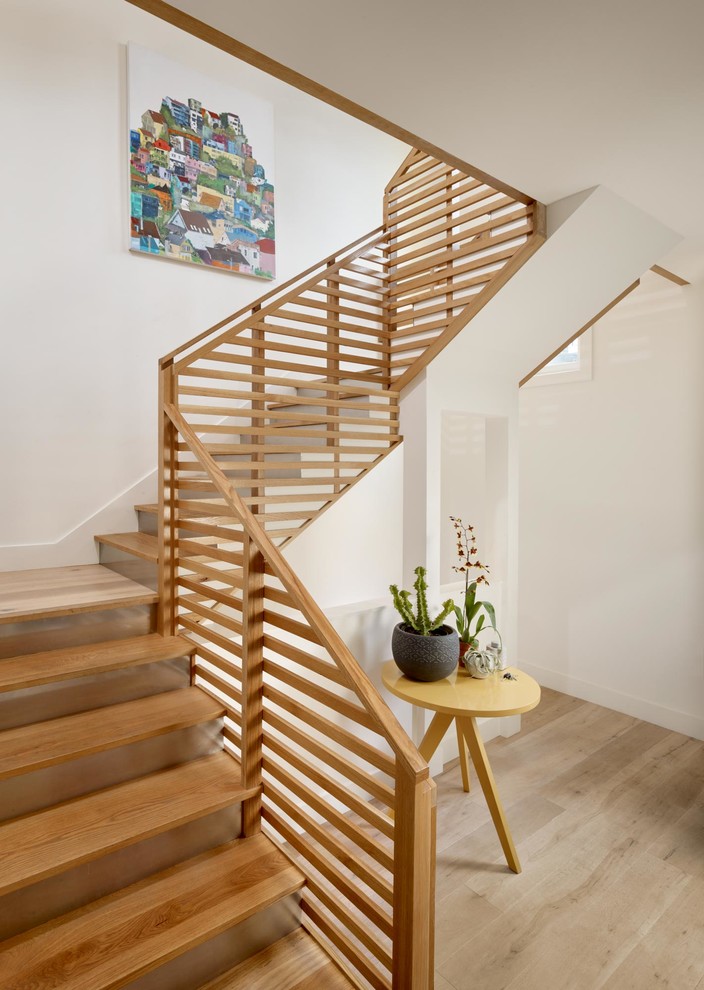 Идея дизайна: п-образная металлическая лестница среднего размера в современном стиле с деревянными ступенями и деревянными перилами