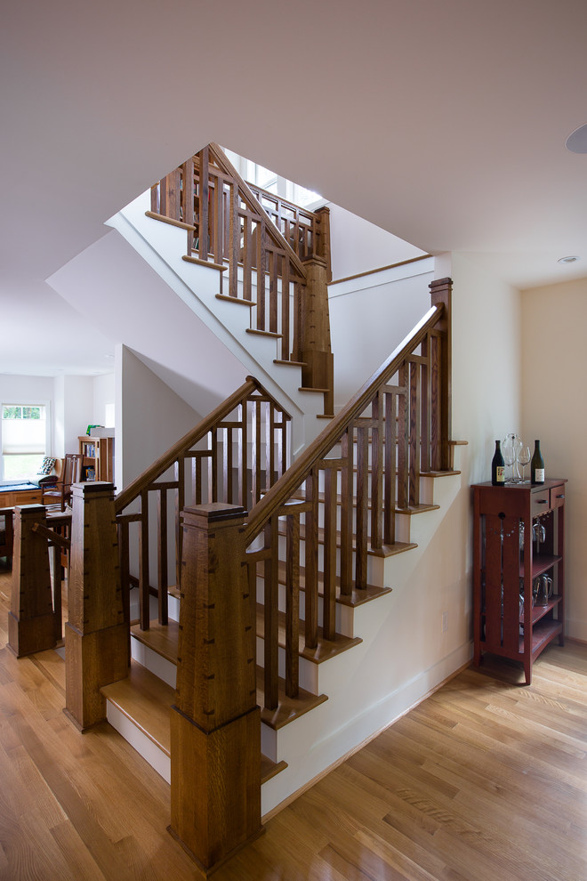 На фото: п-образная лестница среднего размера в стиле кантри с деревянными ступенями, крашенными деревянными подступенками и деревянными перилами с