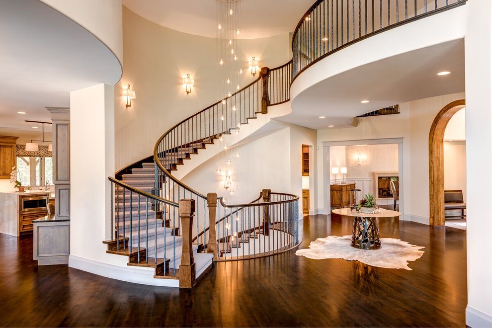 Diseño de escalera curva clásica renovada extra grande con escalones de madera y contrahuellas de madera