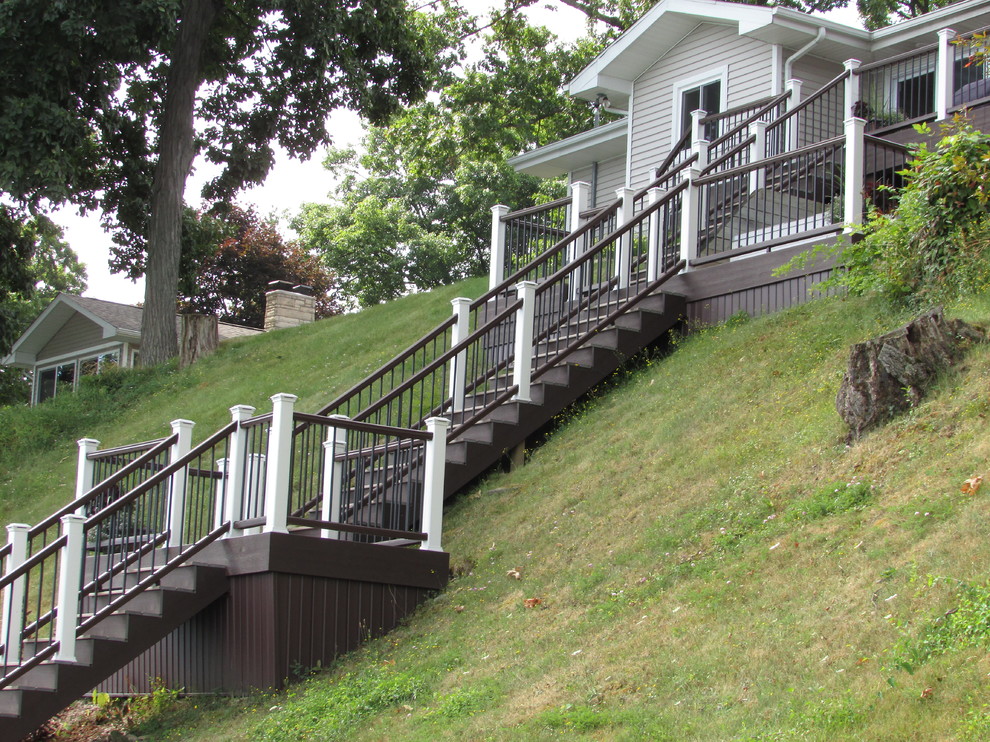 Cette photo montre un très grand escalier droit chic avec des marches en bois, des contremarches en bois et un garde-corps en matériaux mixtes.