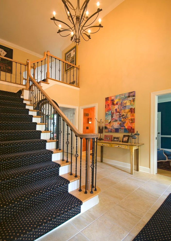 Стильный дизайн: большая угловая лестница в стиле неоклассика (современная классика) с ступенями с ковровым покрытием и ковровыми подступенками - последний тренд