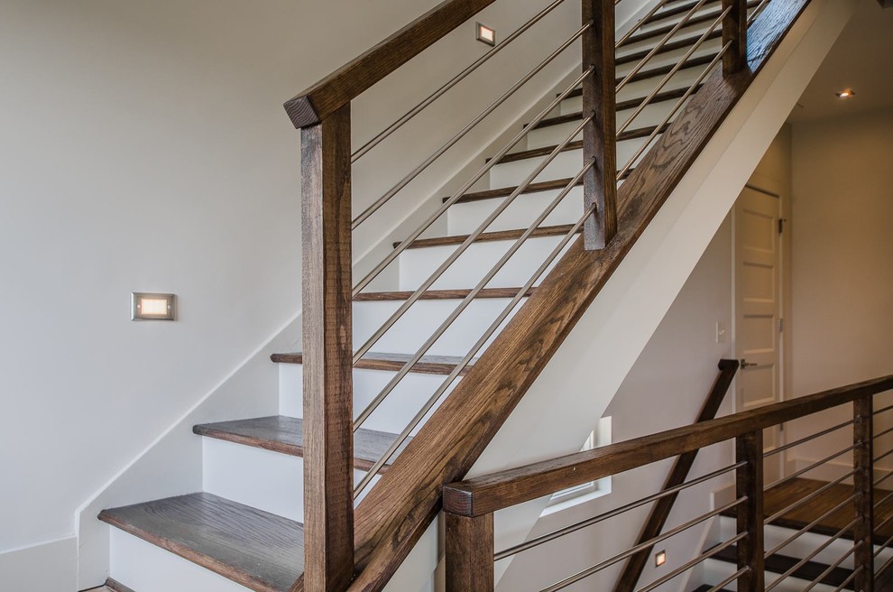 На фото: большая п-образная лестница в современном стиле с деревянными ступенями и крашенными деревянными подступенками