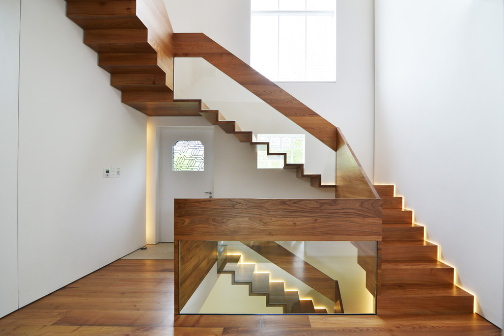 На фото: большая п-образная деревянная лестница в современном стиле с деревянными ступенями