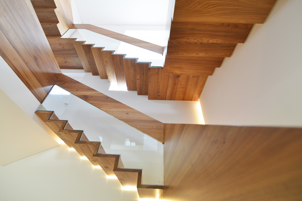 This is an example of a large contemporary metal u-shaped staircase in London with metal risers.