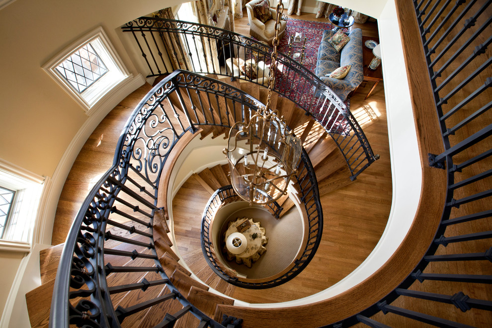 Inspiration for a large classic wood spiral staircase in Denver with wood risers.