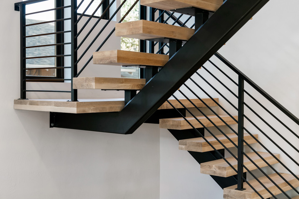 Aménagement d'un escalier sans contremarche flottant classique de taille moyenne avec des marches en bois et un garde-corps en métal.