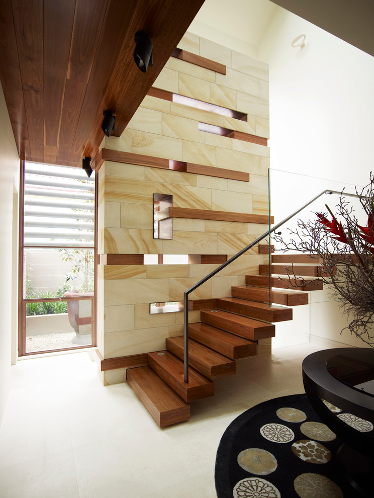 Foto de escalera actual con escalones de madera, contrahuellas de madera y barandilla de metal