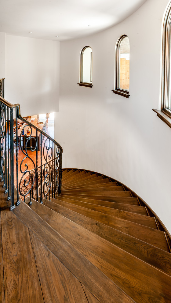 Idée de décoration pour un grand escalier droit méditerranéen avec des marches en bois et des contremarches carrelées.