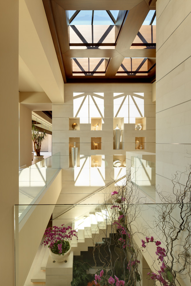 Идея дизайна: большая угловая лестница в современном стиле с ступенями из известняка и металлическими перилами