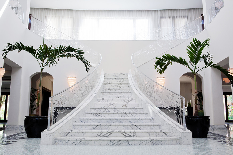 Стильный дизайн: угловая лестница в современном стиле с мраморными ступенями, подступенками из мрамора и металлическими перилами - последний тренд