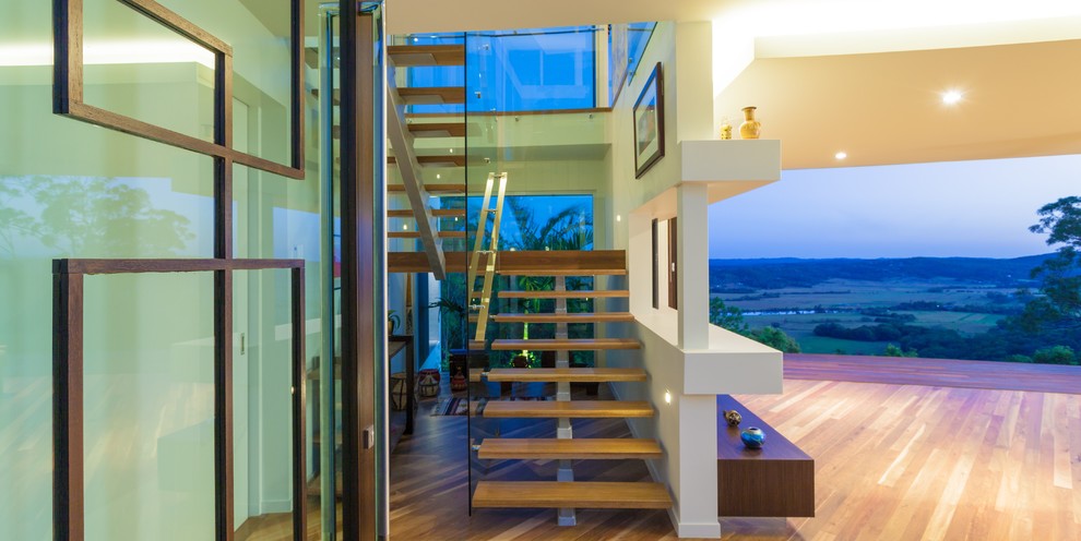 Inspiration pour un grand escalier sans contremarche minimaliste en U avec des marches en bois et éclairage.