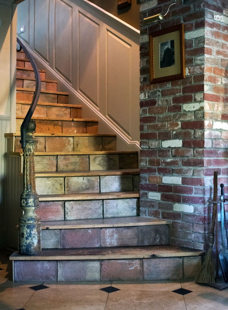 Источник вдохновения для домашнего уюта: изогнутая лестница среднего размера в стиле рустика с подступенками из плитки и деревянными ступенями