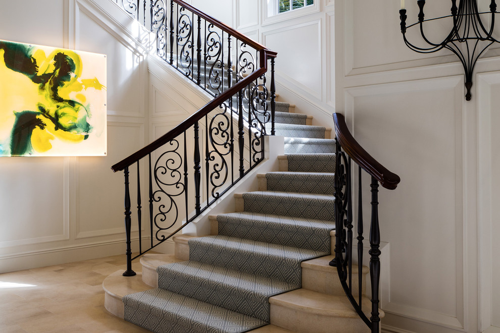 На фото: п-образная металлическая лестница среднего размера в классическом стиле с ступенями с ковровым покрытием и деревянными перилами с