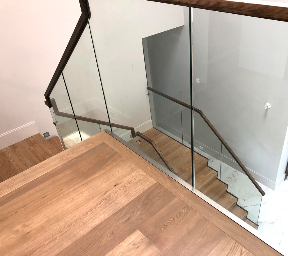 Modelo de escalera en U minimalista de tamaño medio con escalones de madera, contrahuellas de madera y barandilla de vidrio