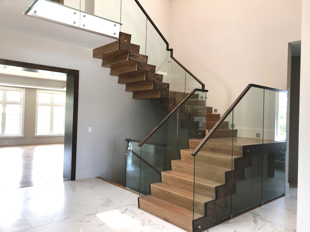 Ejemplo de escalera en U minimalista de tamaño medio con escalones de madera, contrahuellas de madera y barandilla de vidrio
