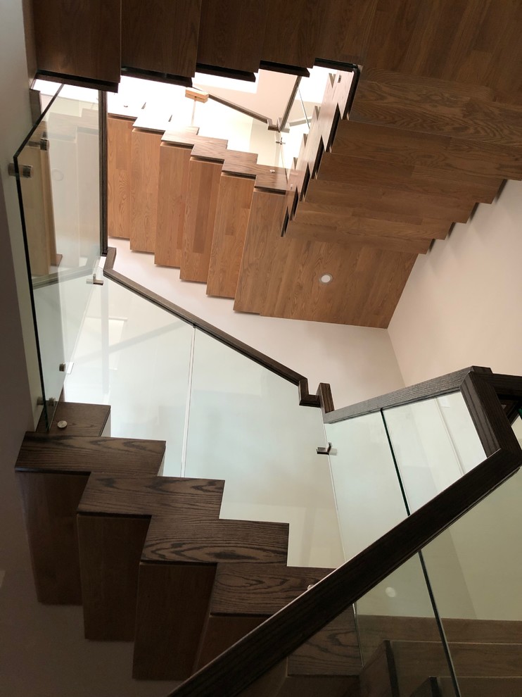 Example of a mid-sized minimalist wooden u-shaped glass railing staircase design in Toronto with wooden risers