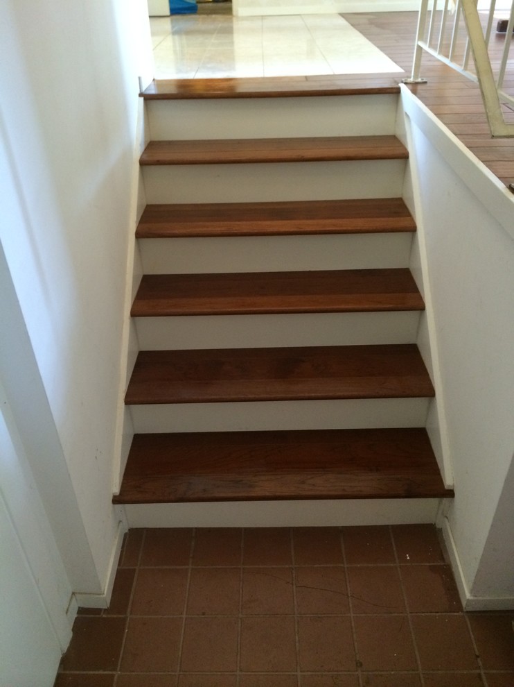 На фото: лестница с деревянными ступенями и крашенными деревянными подступенками с