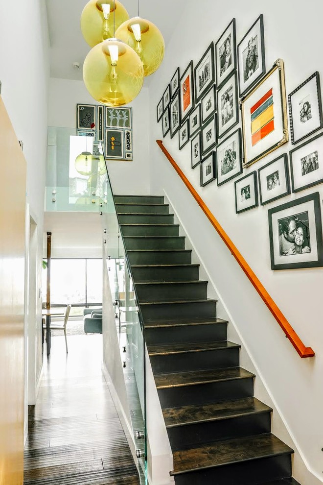 Diseño de escalera recta actual con escalones de madera pintada, contrahuellas de madera y barandilla de vidrio