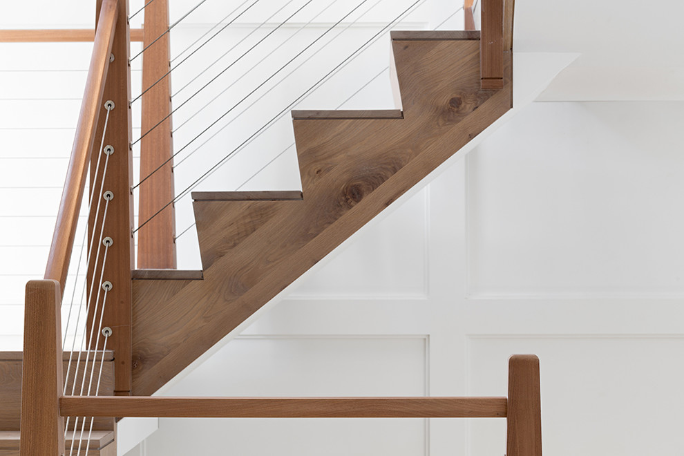 Exemple d'un grand escalier bord de mer en U avec des marches en bois et des contremarches en bois.