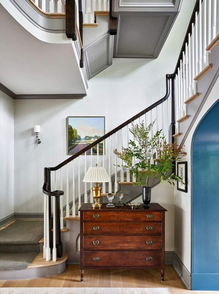 Cette image montre un escalier peint traditionnel en L avec des marches en bois et un garde-corps en bois.