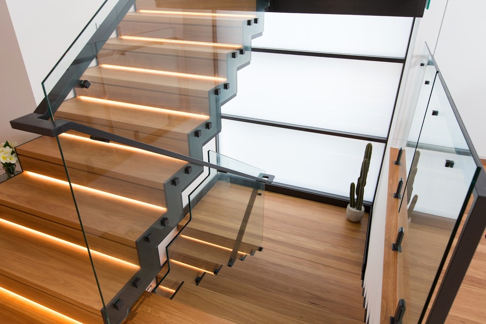 Medium sized contemporary wood curved metal railing staircase in Newcastle - Maitland with wood risers.