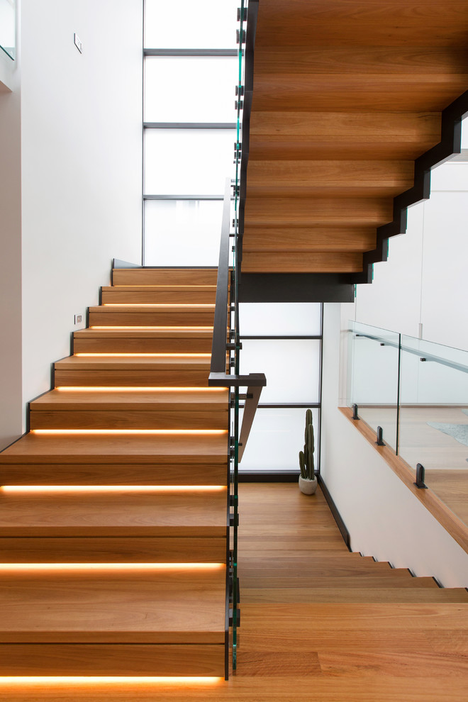 Imagen de escalera suspendida actual grande con escalones de madera y contrahuellas de madera
