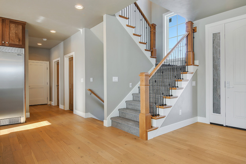 Свежая идея для дизайна: п-образная лестница в стиле фьюжн с ступенями с ковровым покрытием, ковровыми подступенками и деревянными перилами - отличное фото интерьера