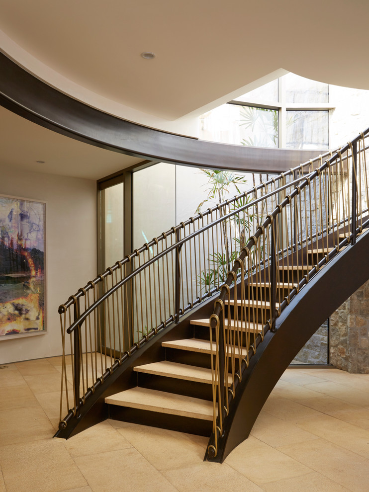 Ejemplo de escalera curva contemporánea grande con contrahuellas de metal