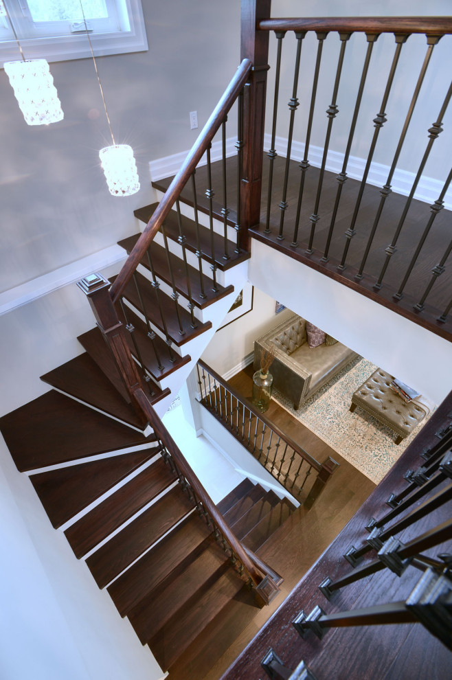 Photo of a medium sized classic wood u-shaped wood railing staircase in Toronto with painted wood risers.