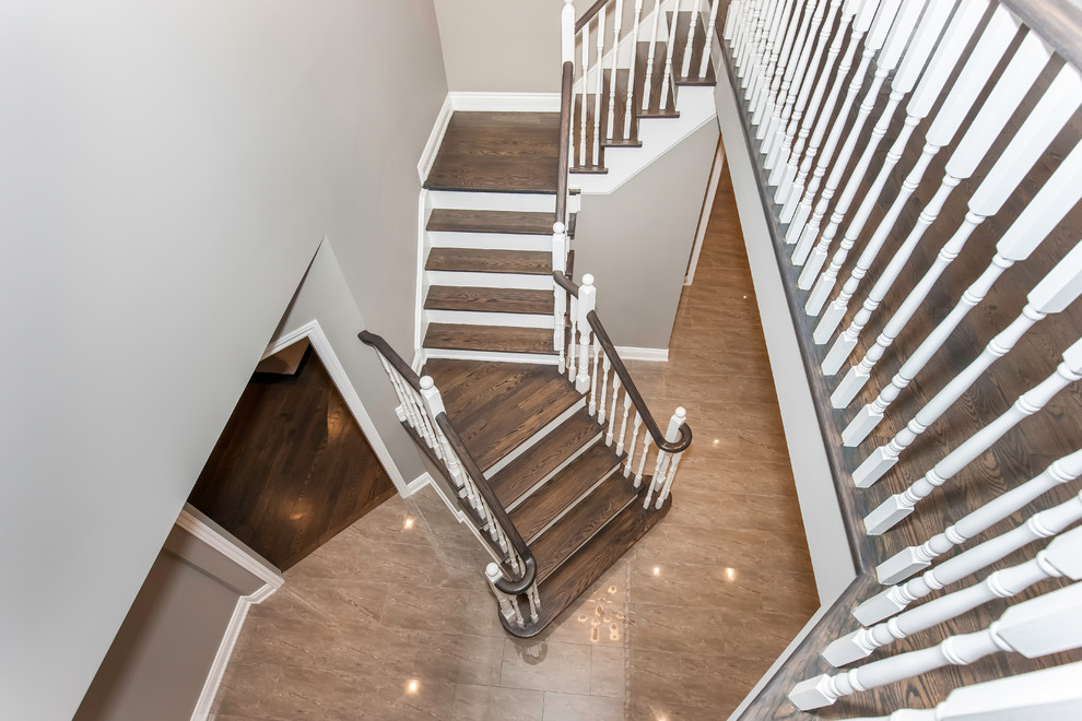 Inspiration for a large traditional wood u-shaped wood railing staircase in Toronto with painted wood risers.
