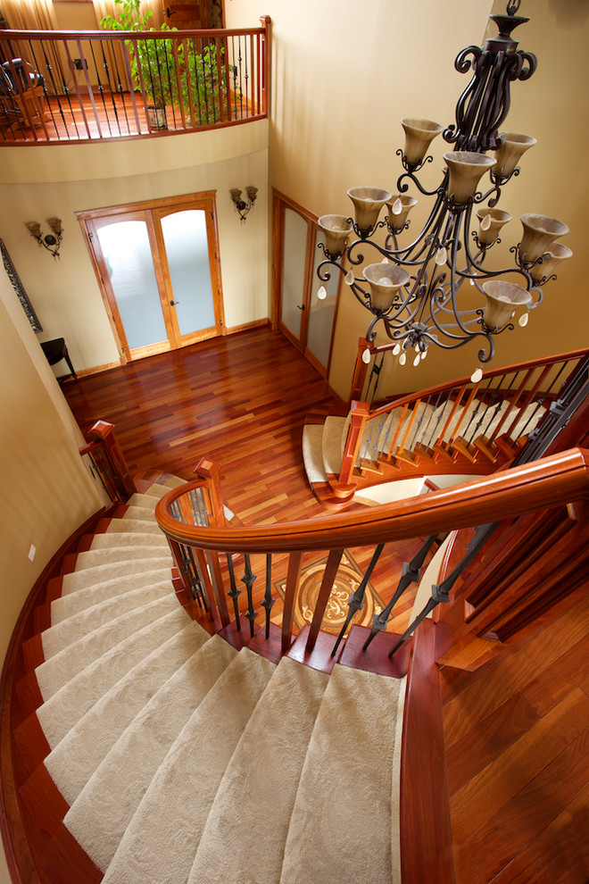 Inspiration pour un grand escalier traditionnel en U avec des marches en moquette, des contremarches en bois et un garde-corps en matériaux mixtes.