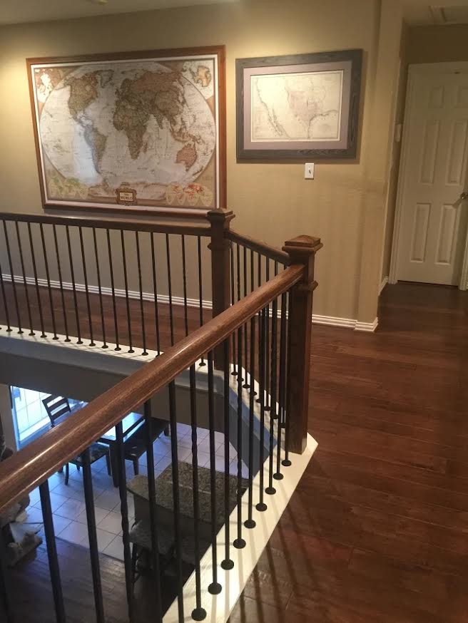 Cette image montre un grand escalier peint courbe design avec des marches en bois et un garde-corps en métal.