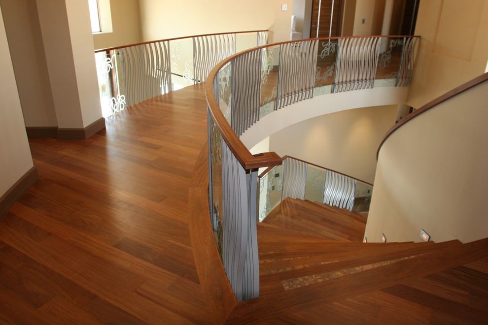Свежая идея для дизайна: изогнутая деревянная лестница в стиле модернизм с деревянными ступенями - отличное фото интерьера