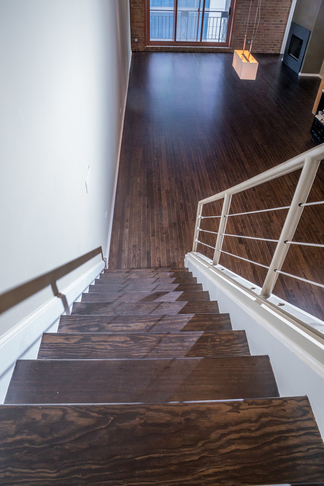 Exemple d'un escalier droit moderne de taille moyenne avec des marches en bois, des contremarches en bois et un garde-corps en câble.