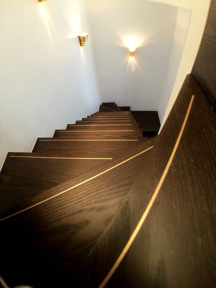 Large midcentury wood l-shaped staircase in New York with wood risers.