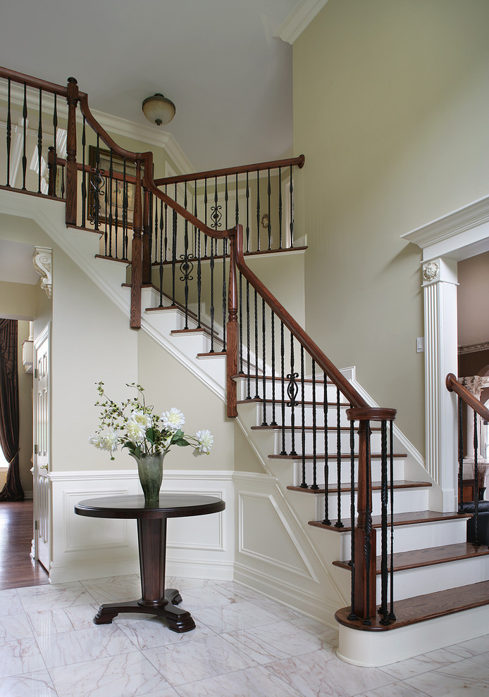 Traditional wood staircase in New York with painted wood risers and feature lighting.