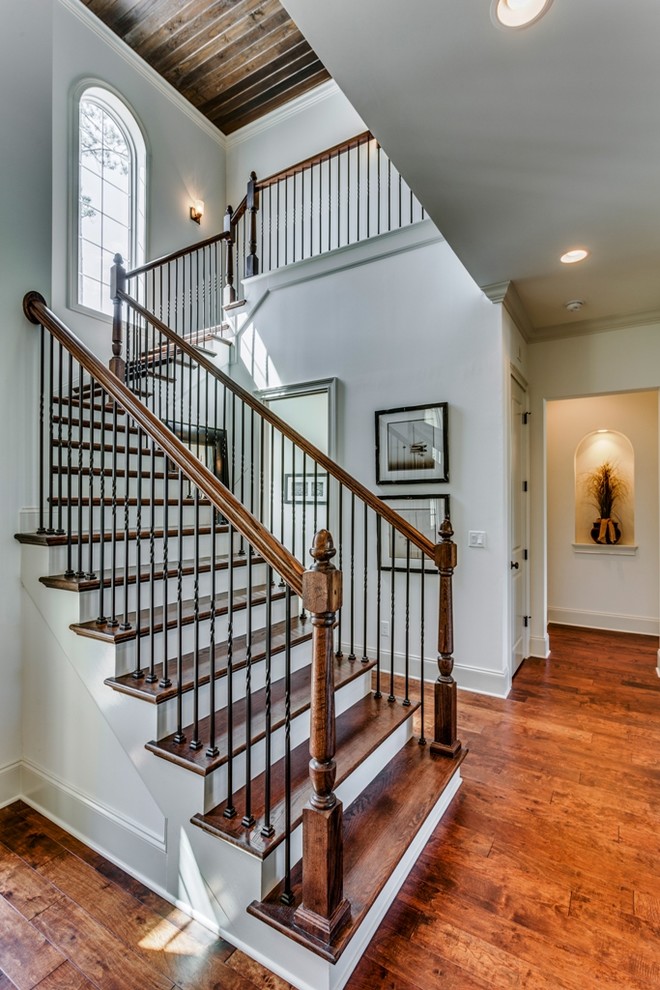 Large mediterranean wood u-shaped staircase in Jacksonville with wood risers.
